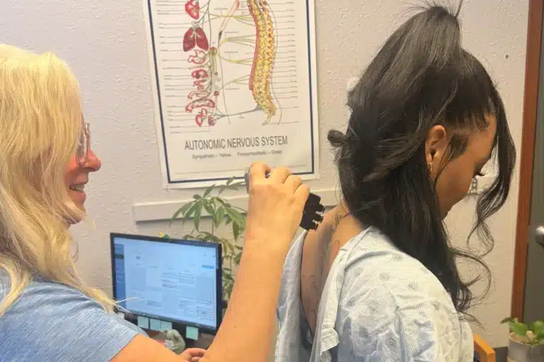 Clinic provider assessing the back of a patient’s neck in Tacoma