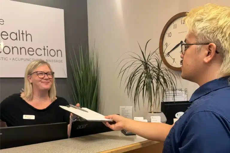 Tacoma clinic receptionist providing paperwork to a patient