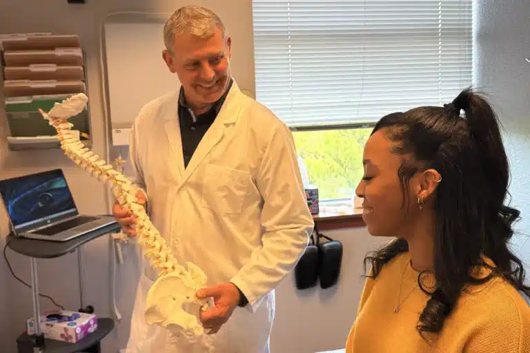 Tacoma chiropractor explaining spinal care with an anatomical model